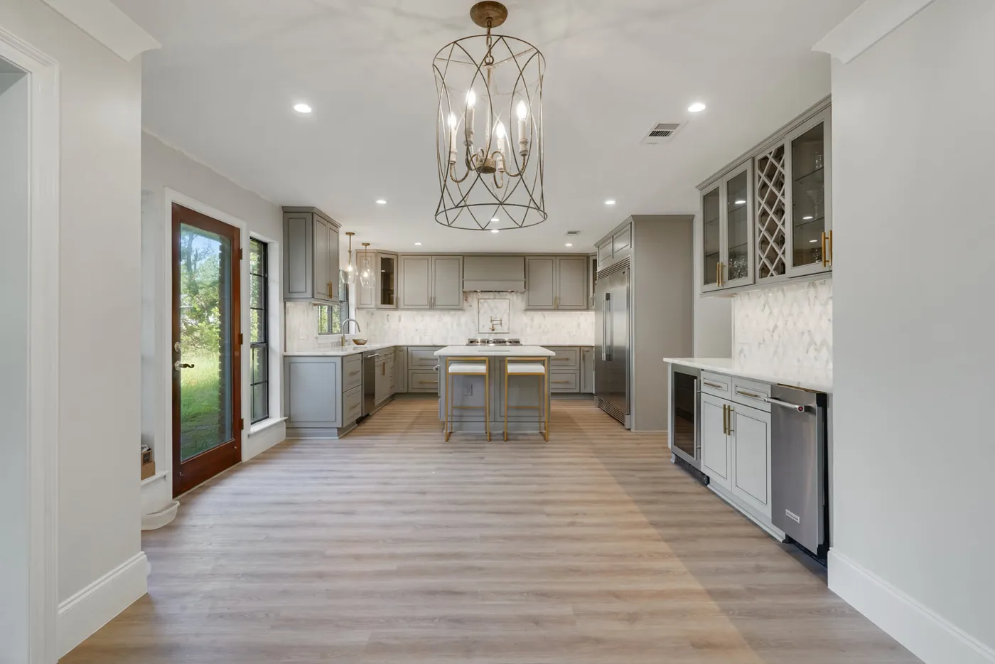 Bright kitchen with light wood-look luxury vinyl plank flooring installed by New Orleans Flooring
